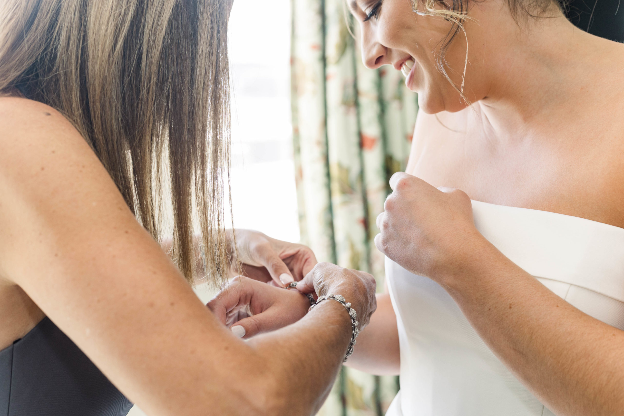mom helping bride put on a bracelet at Bay Club Mattapoisett wedding