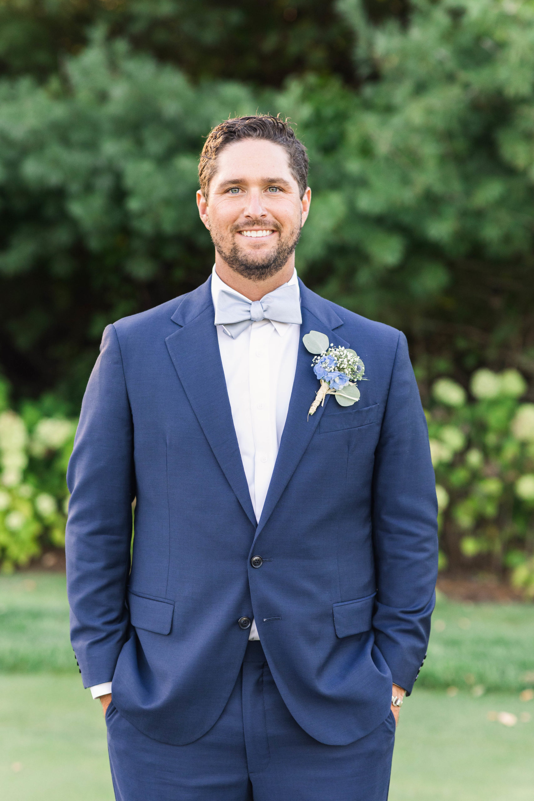 groom smiling at the camera in a navy suit during his Bay Club Mattapoisett wedding