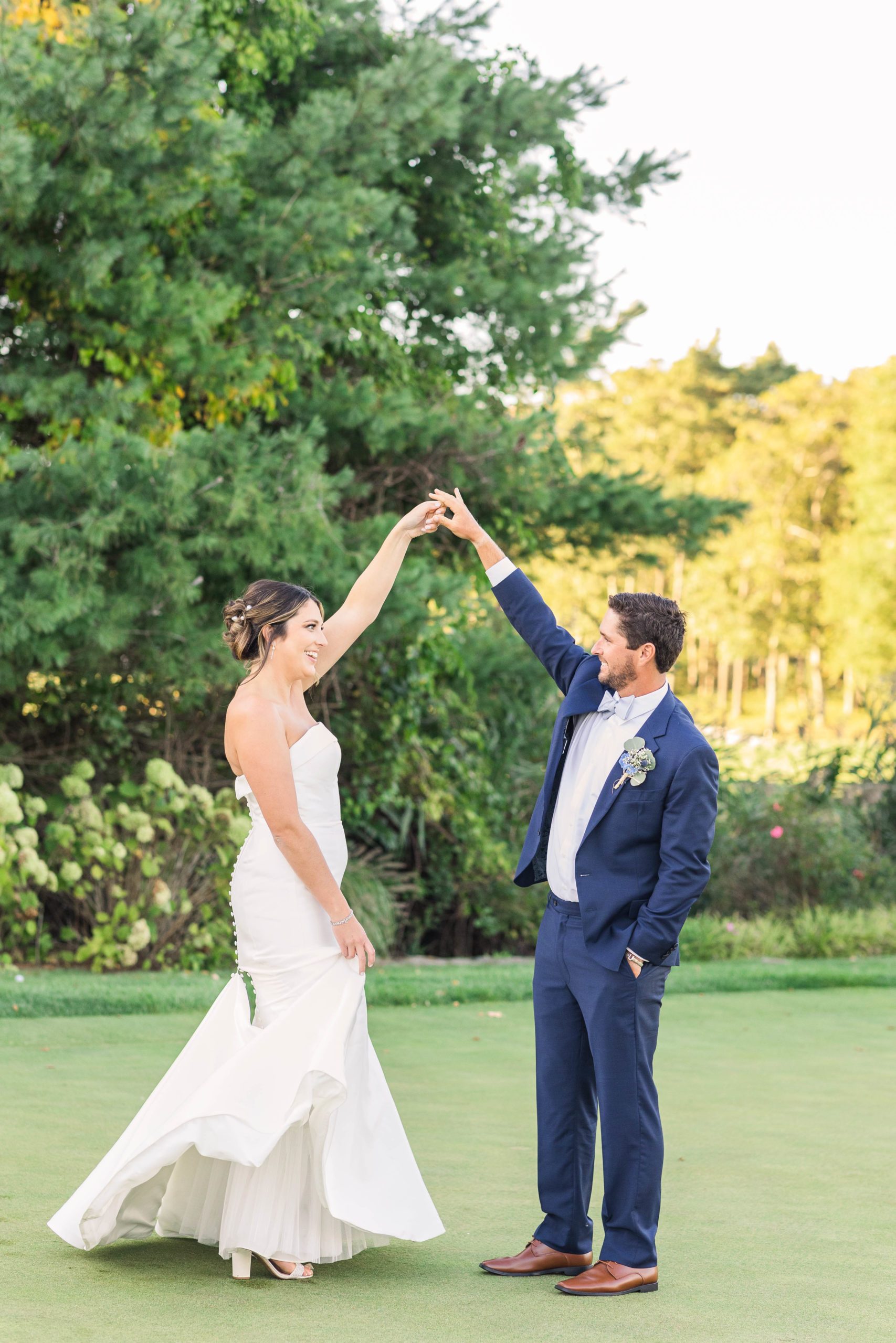 bride and groom dancing in a field at their Bay Club Mattapoisett wedding