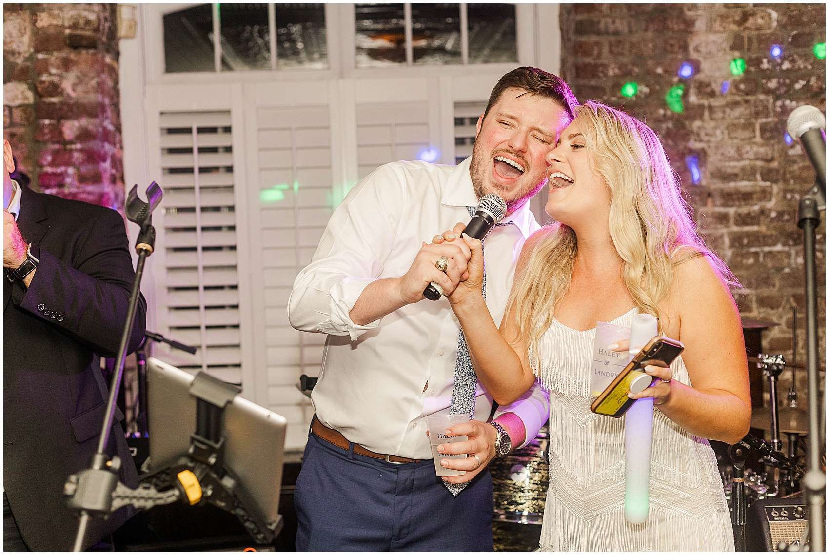 newlywed couple singing karaoke during their reception at Historic Rice mill wedding venue